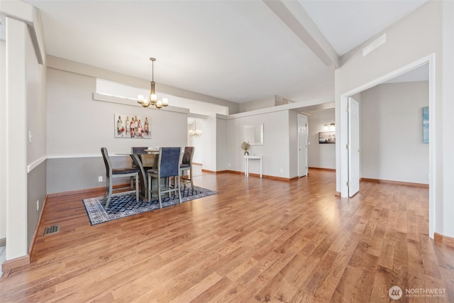 dining area with baseboards, an inviting chandelier, visible vents, and light wood-type flooring