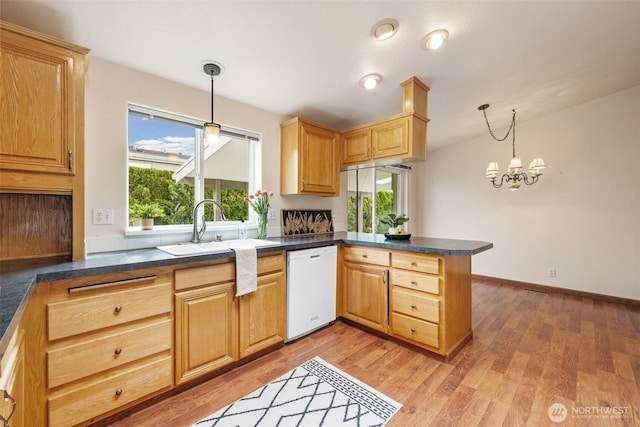 kitchen featuring a sink, plenty of natural light, a peninsula, and dishwasher