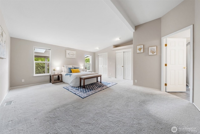 bedroom featuring carpet flooring, multiple closets, lofted ceiling with beams, and multiple windows