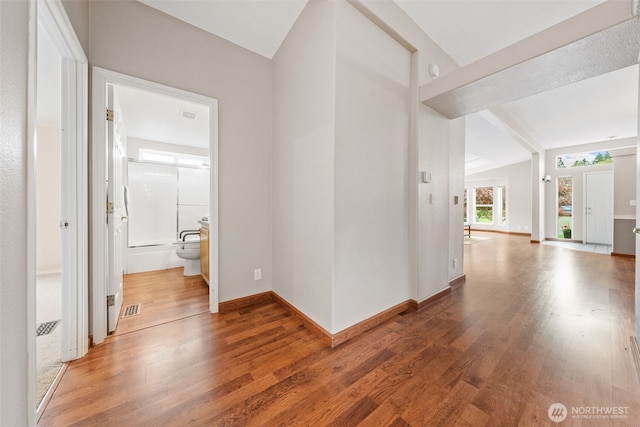 corridor with visible vents, baseboards, and wood finished floors