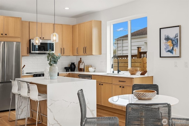 8018 24th Ave NW, Seattle, WA 98117 - kitchen with appliances with stainless steel finishes, a sink, tasteful backsplash, a kitchen island, and light countertops