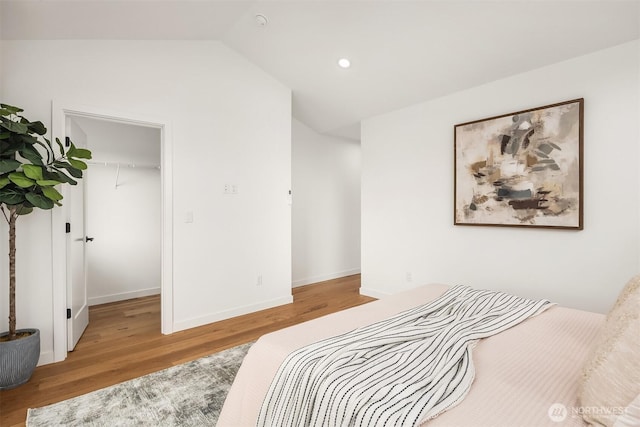 8018 24th Ave NW, Seattle, WA 98117 - bedroom with wood finished floors, a walk in closet, lofted ceiling, baseboards, and recessed lighting