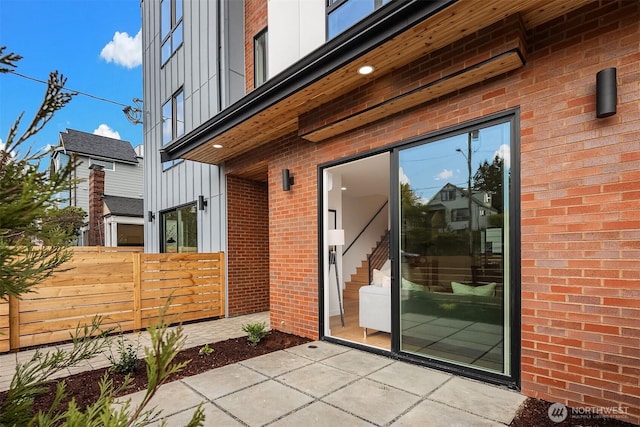 8018 24th Ave NW, Seattle, WA 98117 - view of exterior entry with a patio, brick siding, and board and batten siding