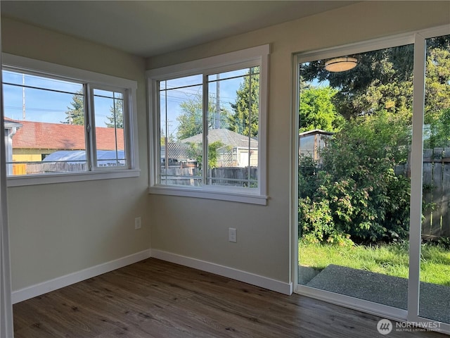 empty room featuring baseboards and dark wood-style flooring