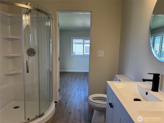 bathroom featuring wood finished floors, healthy amount of natural light, and a stall shower