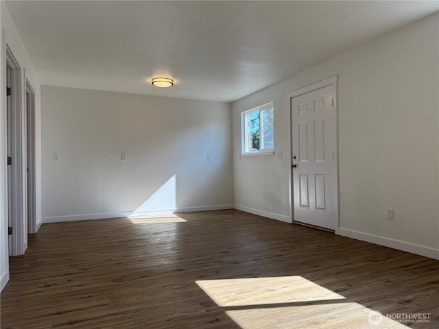 foyer with dark wood finished floors and baseboards