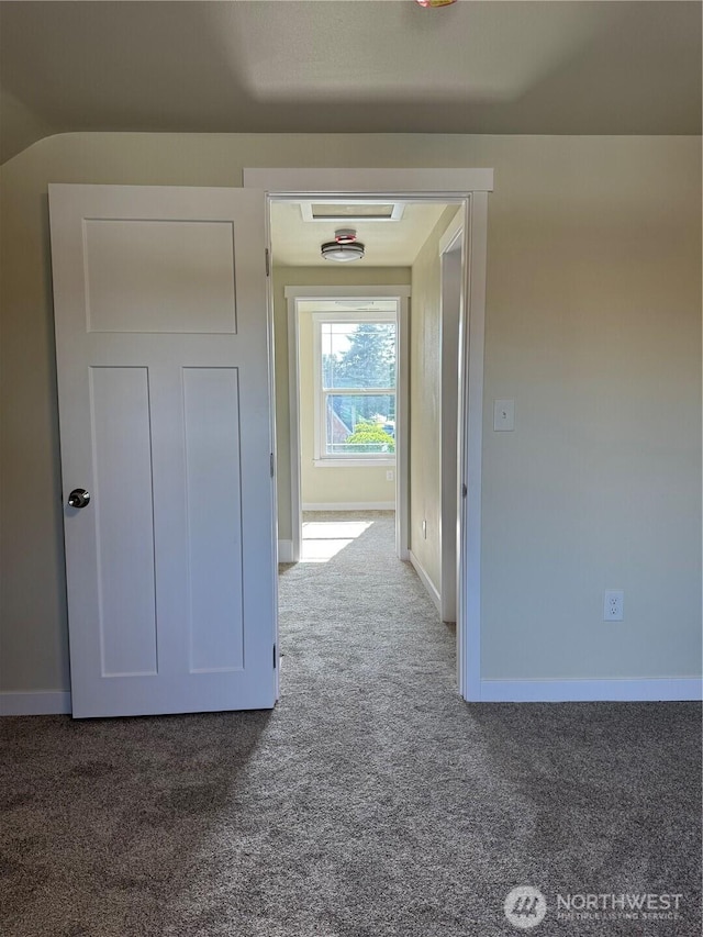 hallway featuring carpet floors and baseboards