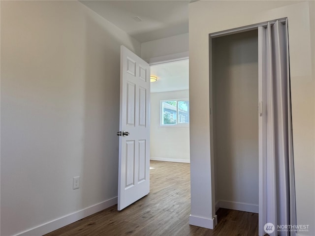 unfurnished bedroom featuring baseboards and dark wood finished floors