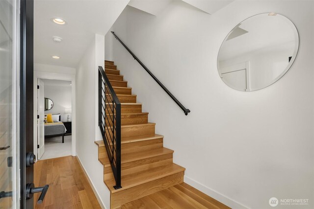staircase featuring baseboards, recessed lighting, and wood finished floors