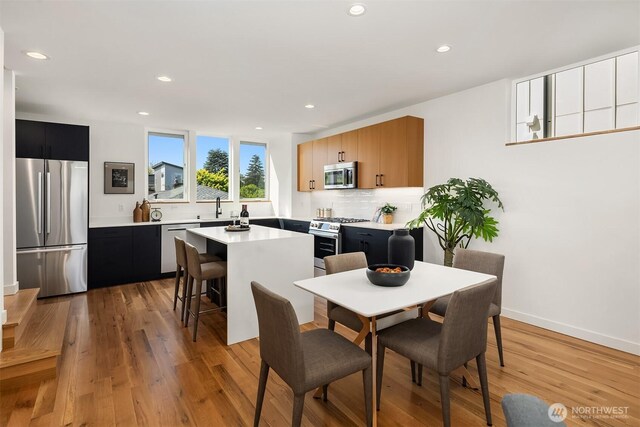 dining room featuring recessed lighting, baseboards, and light wood-style floors