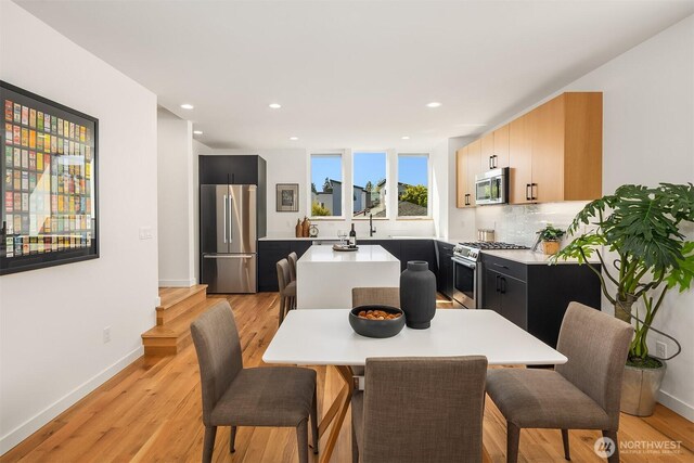dining area with recessed lighting, baseboards, and light wood-type flooring