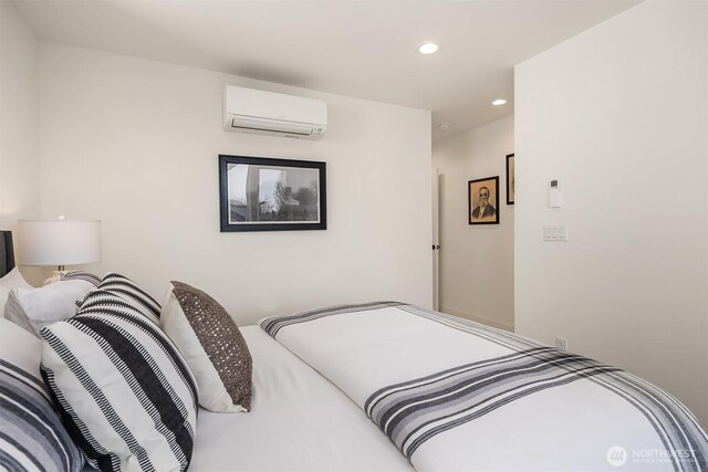 bedroom featuring a wall unit AC and recessed lighting