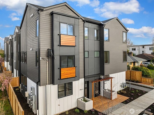 view of front of house with board and batten siding and fence