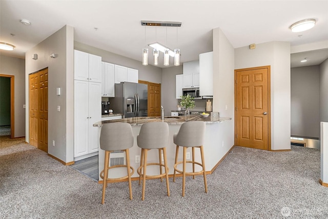 17610 134th Ln SE, Renton, WA 98058 - kitchen featuring carpet floors, stainless steel appliances, a sink, and a peninsula