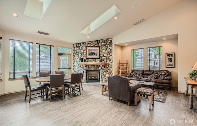 17610 134th Ln SE, Renton, WA 98058 - living room featuring visible vents, wood finished floors, vaulted ceiling with skylight, and a fireplace