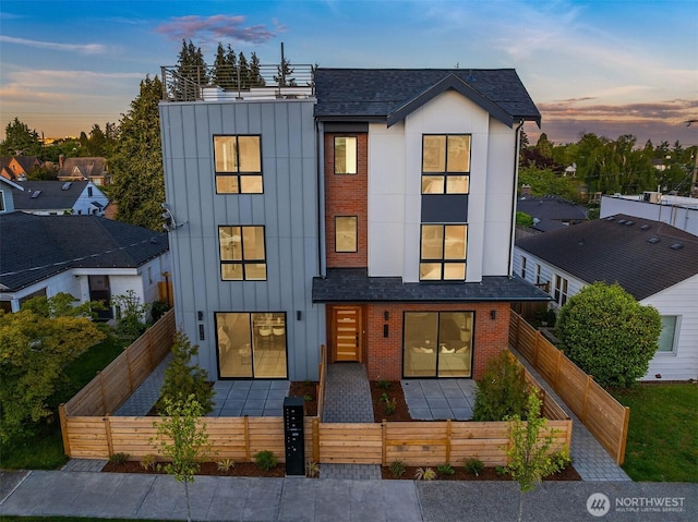 8018 24th Ave NW Unit B, Seattle, WA 98117 - view of front of home with a fenced front yard, board and batten siding, brick siding, roof with shingles, and a gate
