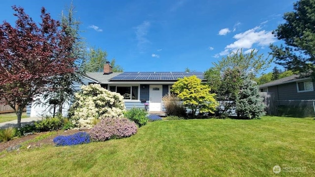 7005 226th Pl SW, Mountlake Terrace, WA 98043 - view of property hidden behind natural elements with a chimney, a garage, fence, roof mounted solar panels, and a front lawn