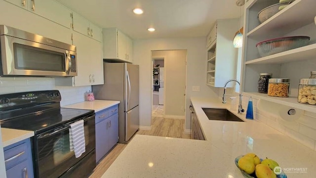 7005 226th Pl SW, Mountlake Terrace, WA 98043 - kitchen with open shelves, decorative backsplash, a sink, light wood-style flooring, and stainless steel appliances