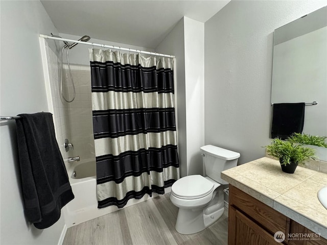 bathroom featuring vanity, wood finished floors, toilet, and shower / bath combo with shower curtain