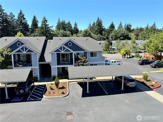 view of front of property with roof with shingles and uncovered parking