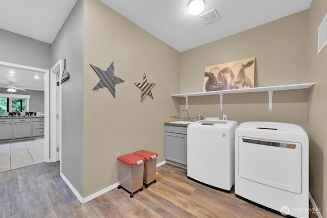17132 156th Ln SE, Yelm, WA 98597 - laundry room featuring cabinet space, washer and dryer, a sink, wood finished floors, and visible vents
