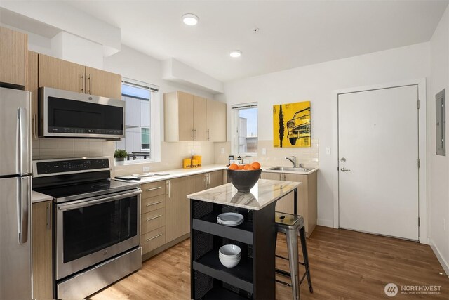 121 12th Ave E Unit 506, Seattle, WA 98102 - kitchen featuring stainless steel appliances, a sink, light countertops, backsplash, and recessed lighting
