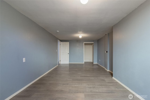 empty room featuring baseboards and wood finished floors