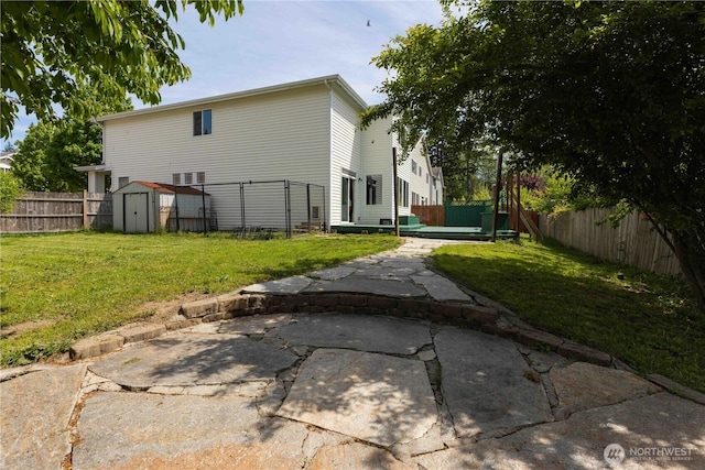 back of house featuring a shed, a patio, and an outbuilding