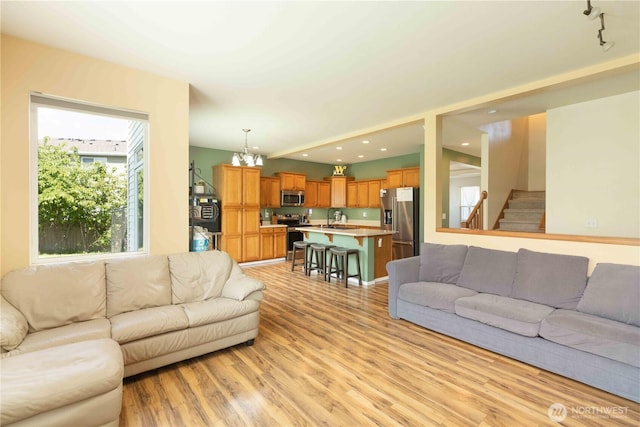 living area featuring light wood-style floors, stairway, and recessed lighting