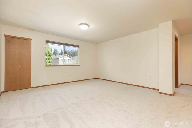 unfurnished bedroom with carpet floors, baseboards, and a closet