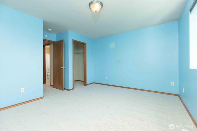 unfurnished bedroom featuring baseboards, carpet floors, and a closet