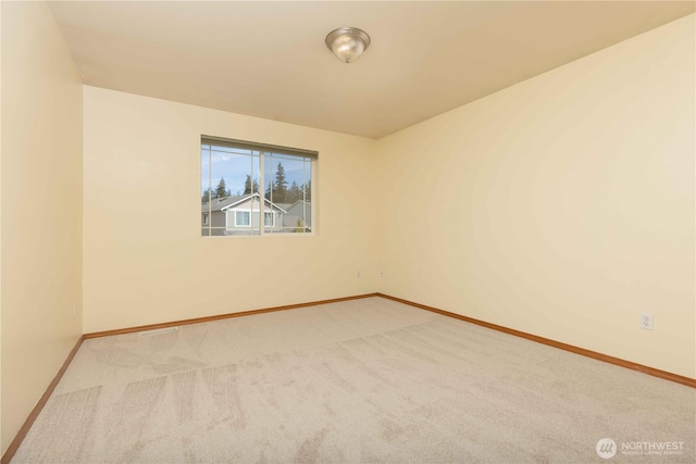 carpeted spare room featuring baseboards