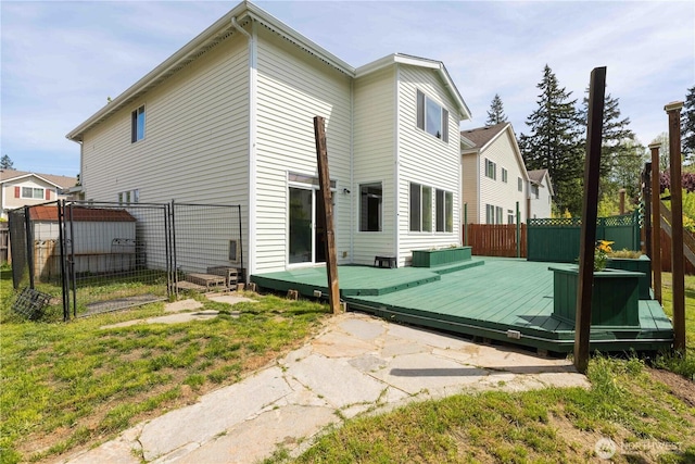 back of property featuring a gate, a fenced backyard, and a deck