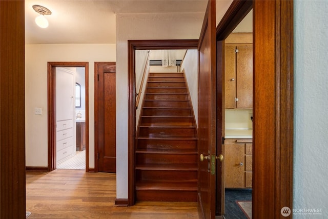 stairway with baseboards and wood finished floors