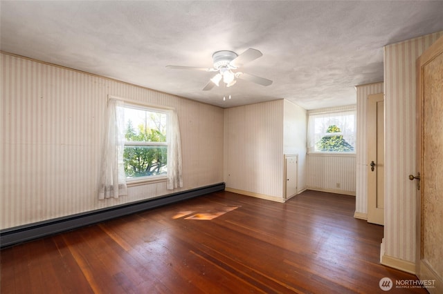 unfurnished room featuring baseboards, ceiling fan, baseboard heating, and hardwood / wood-style floors