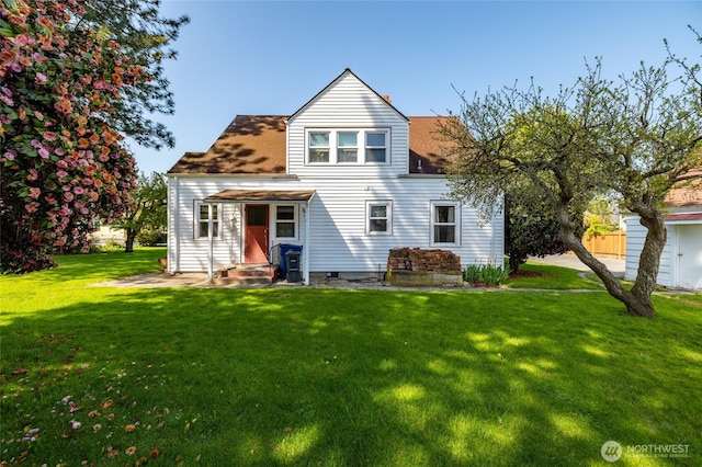 rear view of property with a lawn and roof with shingles