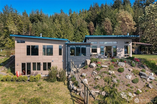 rear view of property featuring a lawn and a patio