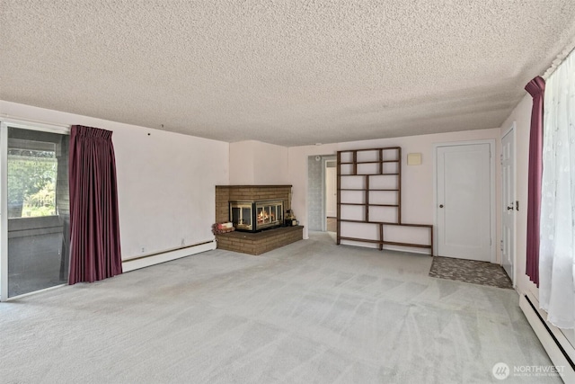 unfurnished living room featuring baseboard heating, a textured ceiling, carpet, and a fireplace