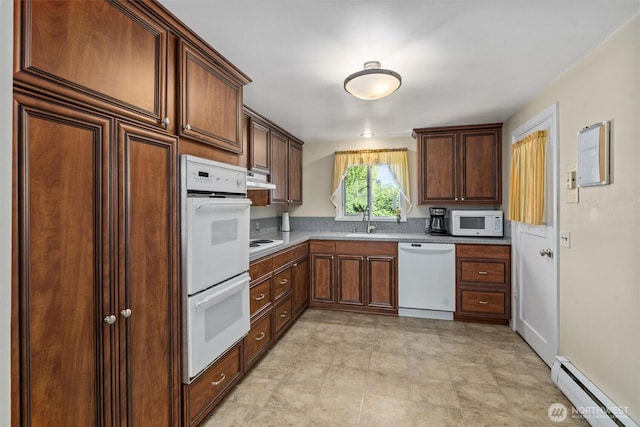 kitchen featuring white appliances, a baseboard heating unit, a sink, under cabinet range hood, and light countertops
