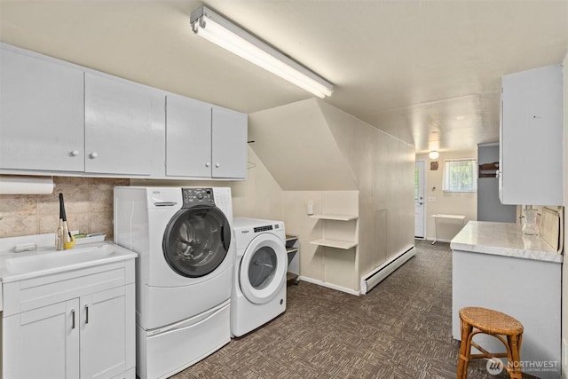 washroom featuring baseboard heating, washing machine and dryer, cabinet space, and dark floors