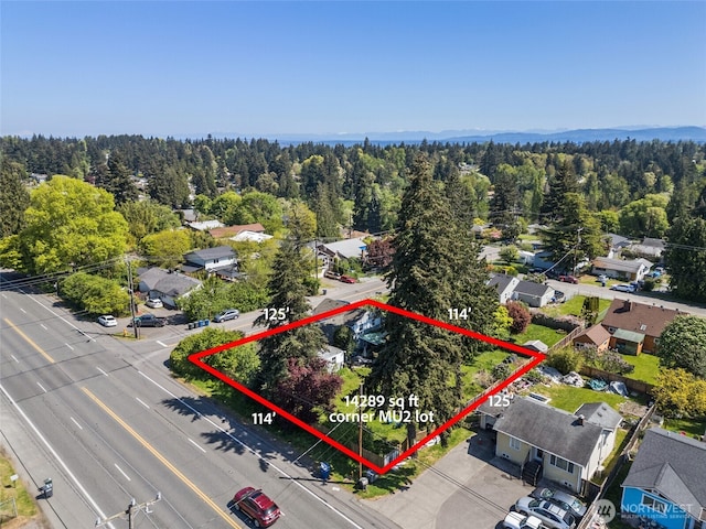 aerial perspective of suburban area featuring property boundaries highlighted and a forest