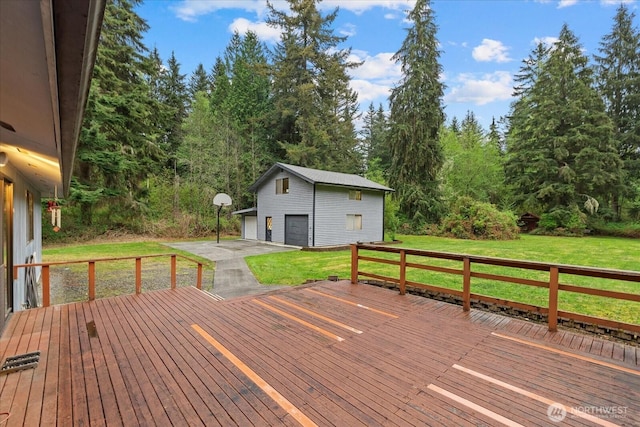 wooden deck with a lawn, a garage, and an outbuilding