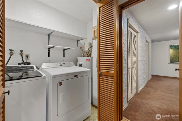 clothes washing area with laundry area, washer and clothes dryer, water heater, and light carpet
