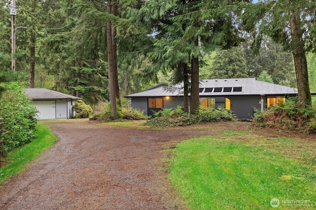 mid-century home with driveway and a detached garage
