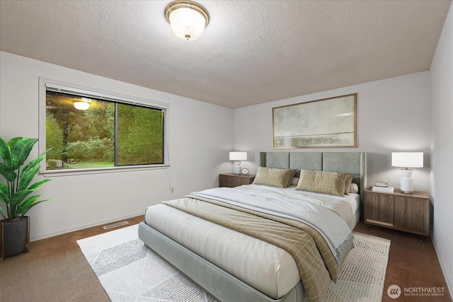 bedroom with carpet flooring, a textured ceiling, and visible vents