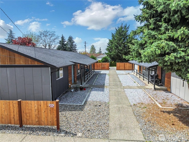 view of home's exterior featuring fence private yard and a shingled roof
