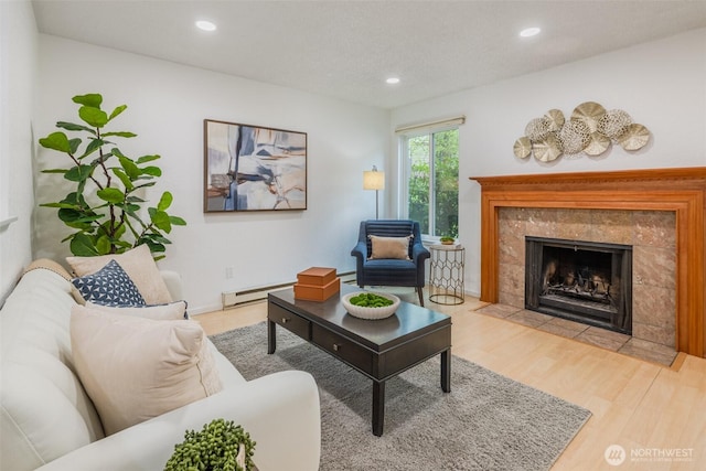 12621 NE 130th Way # D106, Kirkland, WA 98034 - living room featuring wood finished floors, a fireplace, baseboard heating, recessed lighting, and a baseboard heating unit