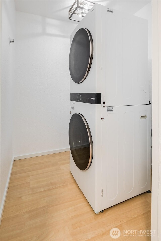 12621 NE 130th Way # D106, Kirkland, WA 98034 - laundry room with laundry area, baseboards, stacked washer and clothes dryer, and light wood-style floors