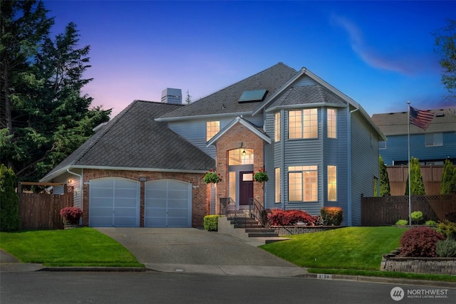 traditional-style home featuring an attached garage, concrete driveway, brick siding, and roof with shingles