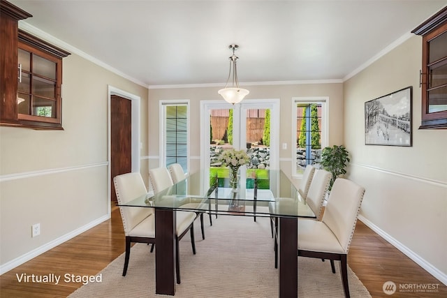 dining room featuring baseboards, wood finished floors, and ornamental molding